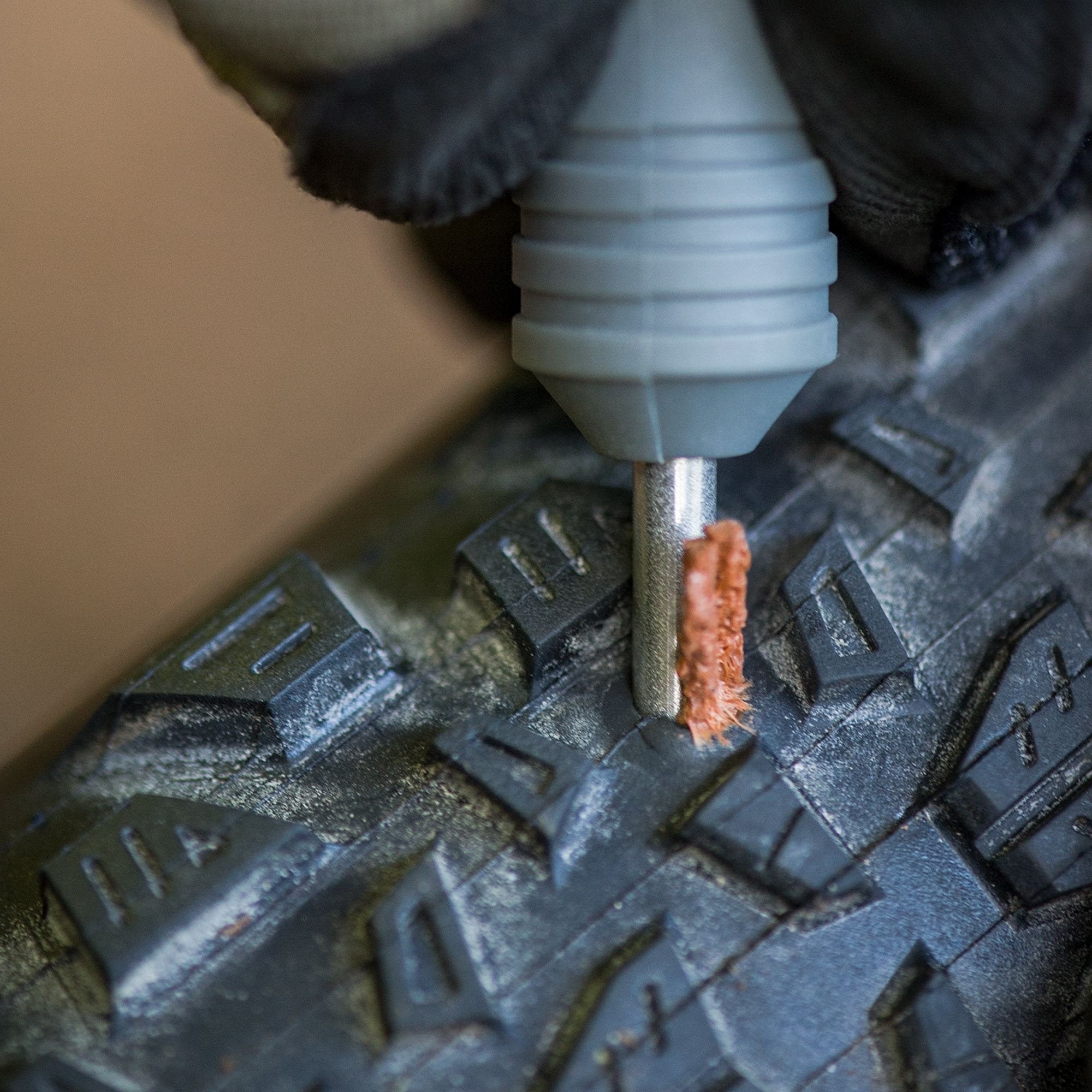 Blackburn tubeless plug kit being pushed into a hole in a mtb tyre