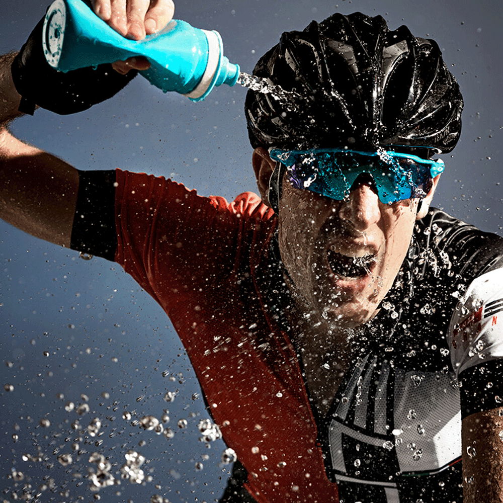 Bike rider quirting his face with water from a fly elite water bottle